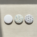 Multiple 32mm customisable button badges on beige background